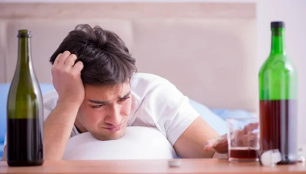 Чоловік алкоголік в ліжку проходить через розпад депресії — стокове фото