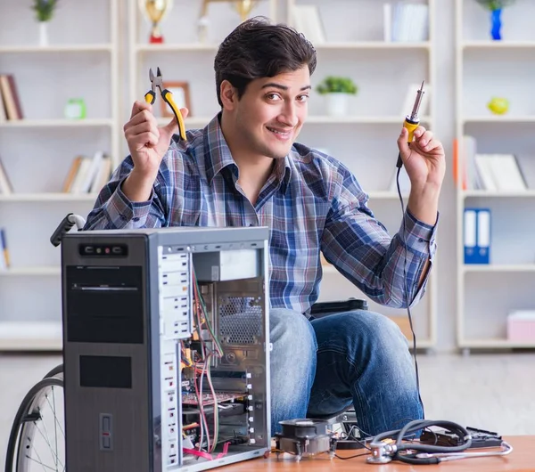 Reparador de computadoras en silla de ruedas trabajando —  Fotos de Stock