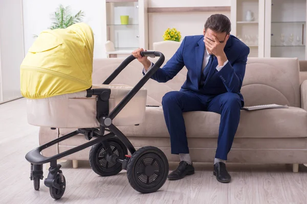 Young businessman looking after baby — Stock Photo, Image