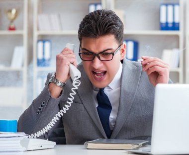 İşadamı ofisinde sigara içiyor.