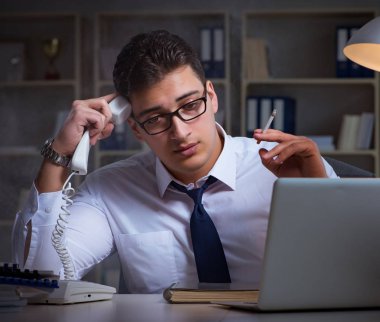 İş adamı telefonda konuşuyor ve ofiste sigara içiyor.