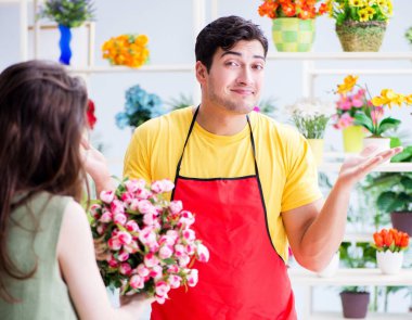 Çiçekçi dükkanında çiçek satıyor.