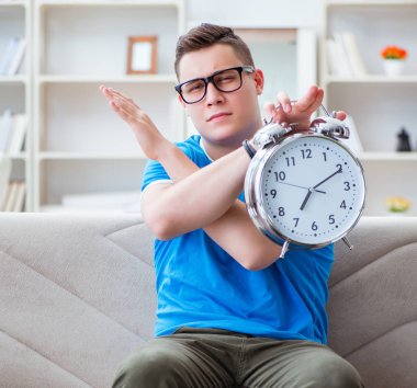 Sınavlara hazırlanan genç öğrenci kanepede ders çalışıyor.