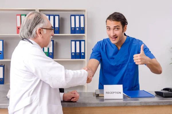 Twee dokters praten bij de receptie in het ziekenhuis. — Stockfoto