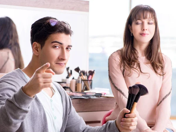 Der Mann schminkt die süße Frau im Schönheitssalon — Stockfoto