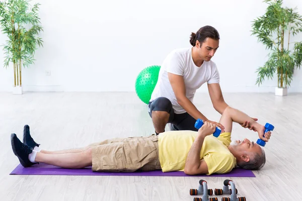 Old man doing exercises indoors