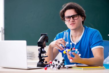 Sınıftaki genç erkek öğrenci.