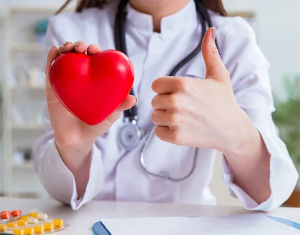 Doctor cardiologist with red heart in the hospital — Stock Photo, Image