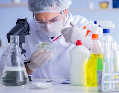 Laboratuvardaki adam yeni temizlik çözeltisi deterjanı test ediyor.
