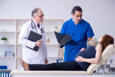 İki doktor genç kadını muayene ediyor.