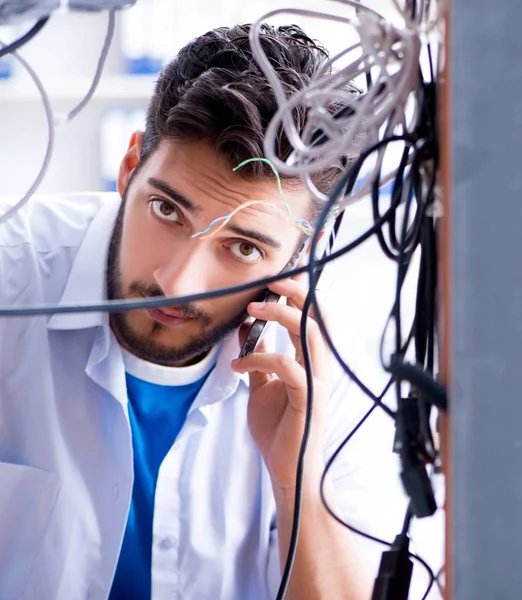 Elektrik teknisyeni tamir konseptinde kabloları çözmeye çalışıyor.