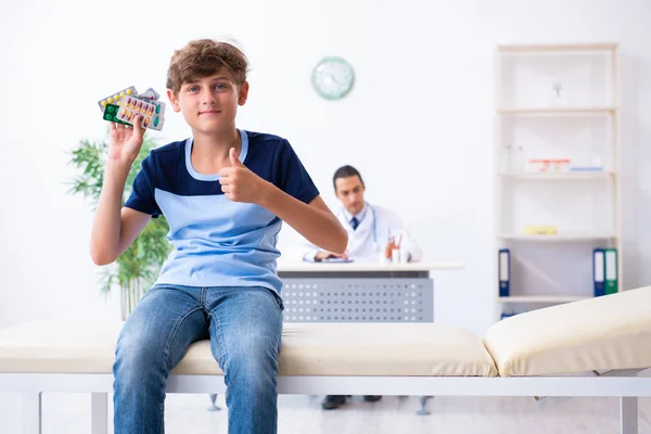 Jovem médico examinando menino na clínica — Fotografia de Stock