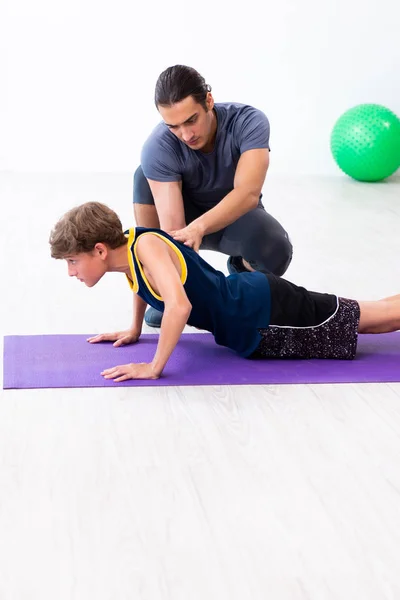 Jovem pai e seu filho fazendo exercícios — Fotografia de Stock