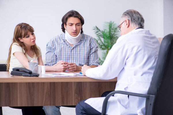 Молодая пара, посещающая пожилого врача