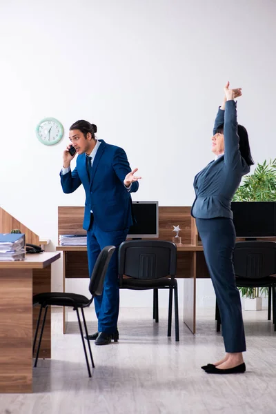 Dos empleados haciendo ejercicios deportivos en la oficina —  Fotos de Stock