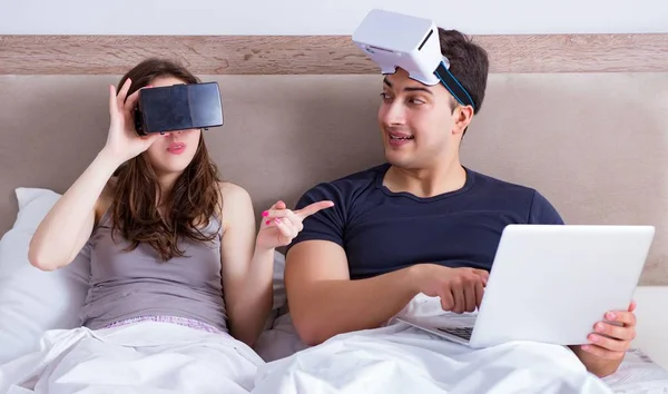 Esposa e marido com óculos de realidade virtual na cama — Fotografia de Stock