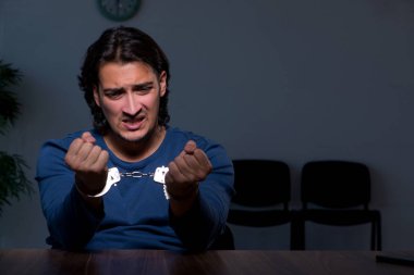 Genç mahkum karanlık odada oturuyor.