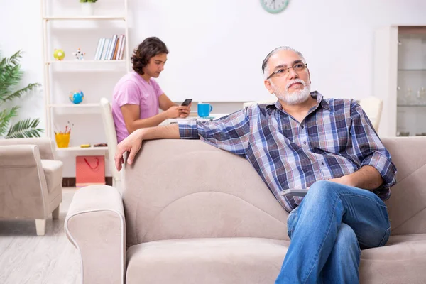 Joven estudiante y su viejo abuelo en casa — Foto de Stock