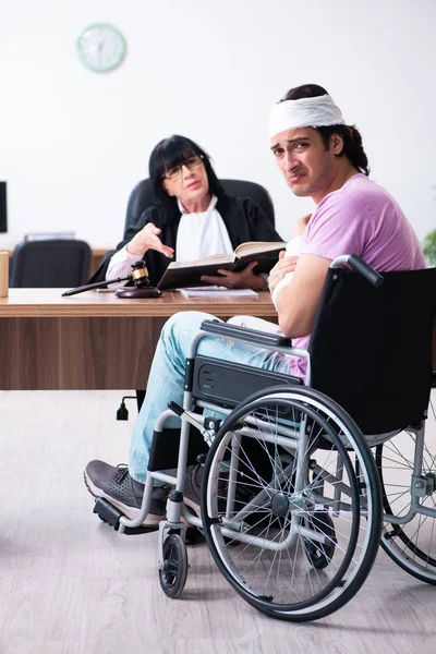 Osoba niepełnosprawna konsultująca się z sędzią w sprawie odszkodowania — Zdjęcie stockowe