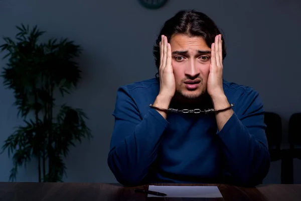 Jonge veroordeelde man zit in donkere kamer — Stockfoto