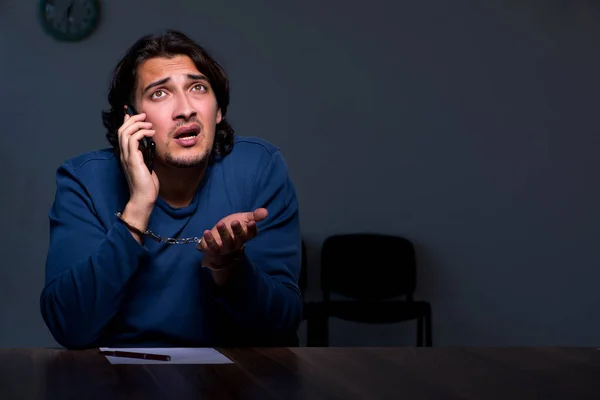 Young convict man sitting in dark room — Stock Photo, Image