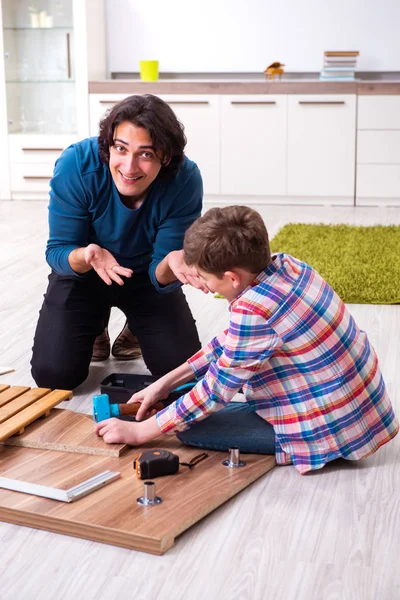 Jovem carpinteiro ensinando seu filho — Fotografia de Stock
