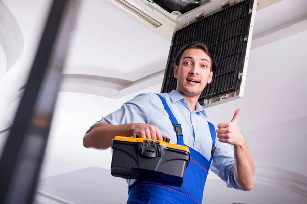 Joven reparador reparación de la unidad de aire acondicionado del techo —  Fotos de Stock