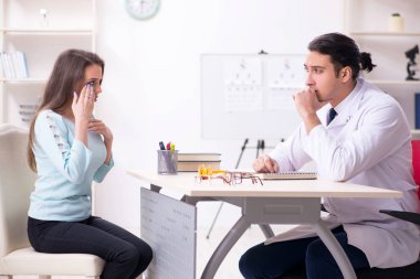 Genç bir kadın, erkek doktoru ziyaret ediyor.