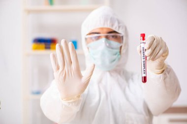 Genç yakışıklı laboratuvar asistanı hastanede kan örnekleri test ediyor.