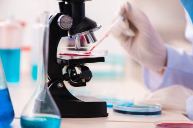 Laboratuvarda çalışan genç bir kadın kimyager.