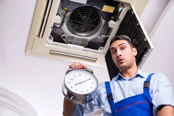 Young repairman repairing ceiling air conditioning unit — Stock Photo, Image
