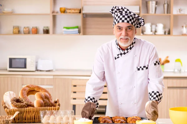 Viejo panadero trabajando en la cocina — Foto de Stock