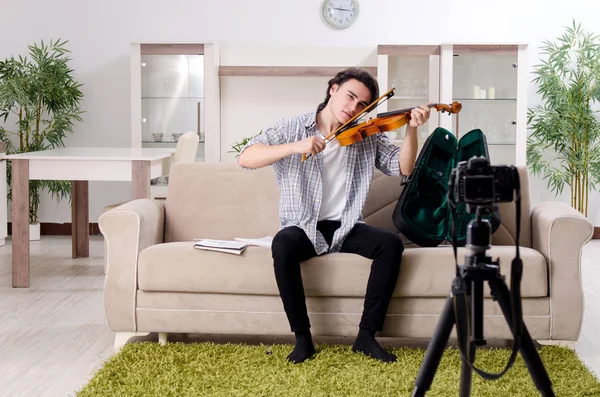 若いです男性ブロガー遊びバイオリンに家 — ストック写真