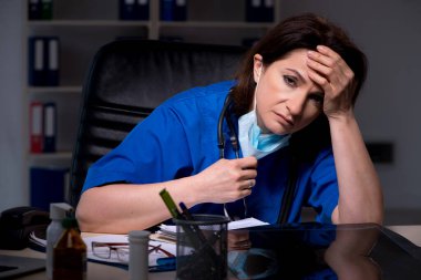 Gece vardiyasında çalışan yaşlı kadın doktor.