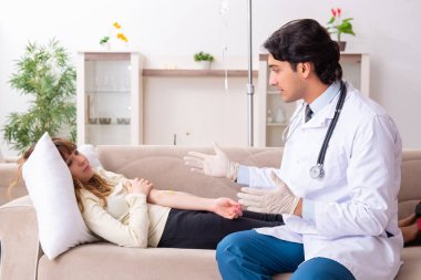 Genç, yakışıklı doktor, kadın hastayı evinde ziyaret ediyor.