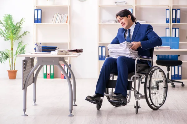Jovem funcionário do sexo masculino em cadeira de rodas que trabalha no escritório — Fotografia de Stock