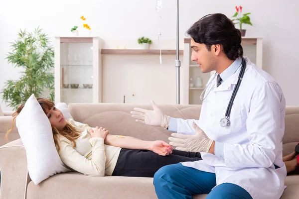 Genç, yakışıklı doktor, kadın hastayı evinde ziyaret ediyor.