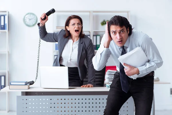 Old female boss and young male employee in the office — Stock Photo, Image