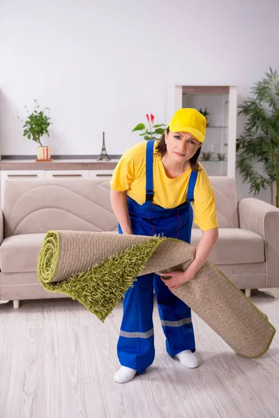 Old female contractor doing housework — Stock Photo, Image