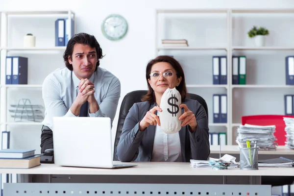 Vecchio capo femminile e giovane dipendente maschile in ufficio — Foto Stock