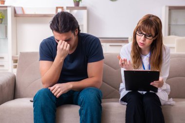 Genç bir erkek hasta kadın psikologla konuşuyor.