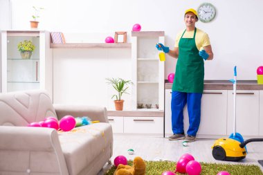 Genç erkek müteahhit partiden sonra ev işi yapıyor.