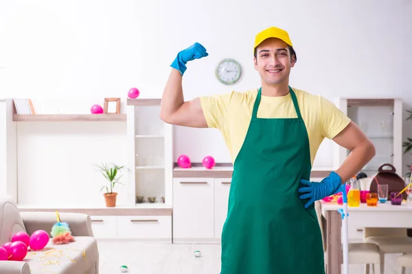 Jovem empreiteiro do sexo masculino fazendo trabalhos domésticos após a festa — Fotografia de Stock