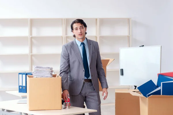 Молодой человек с коробками в офисе — стоковое фото