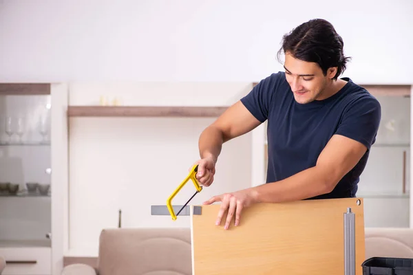 Молодой человек ремонтирует мебель на дому — стоковое фото