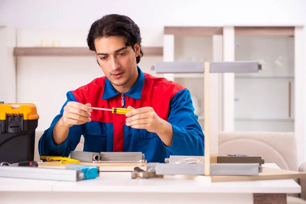 Young contractor repairing furniture at home — Stock Photo, Image