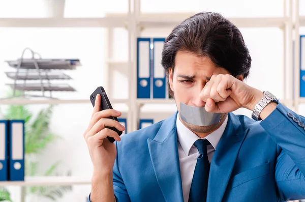 Junge männliche Mitarbeiter mit Klebeband auf dem Mund — Stockfoto