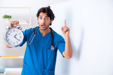 Genç erkek doktor beyaz tahtanın önünde.
