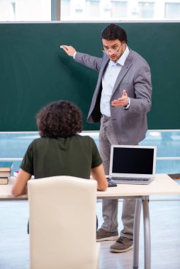 Genç öğretmen ve öğrenci sınıfta.