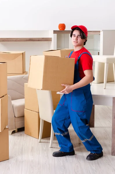 Jovem empreiteiro masculino com caixas trabalhando dentro de casa — Fotografia de Stock